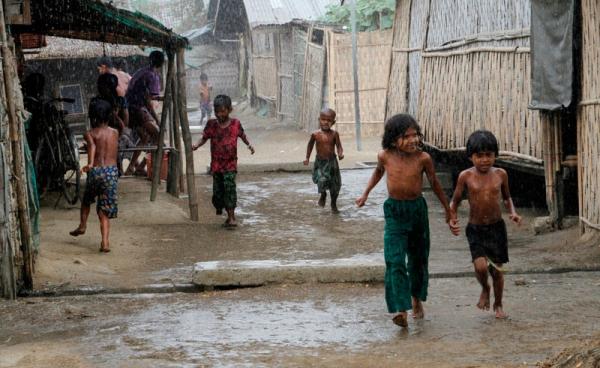 Rohingya children play during rain at an Internally Displaced Persons (IDPs) camp near Sittwe of Rakhine State, western Myanmar, 22 March 2016. Photo: Nyunt Win/EPA