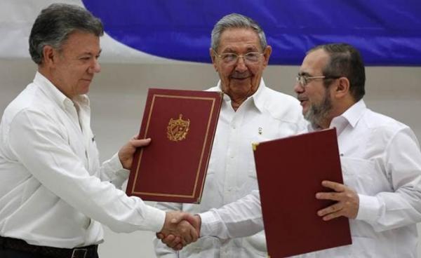 shake hands during a signing ceremony of a cease-fire and rebel disarmament deal, in Havana, Cuba. (AP Photo)