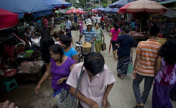 People walk through a street market in Yangon. Photo: AFP