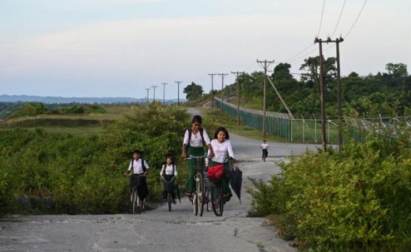 Students riding their bicycles outside the Daewoo facility in Kyaukphyu, Rakhine State. Photo: Ye Aung Thu/AFP