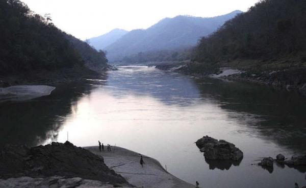 Plagued by war for decades - Here Karen villagers (small figures in foreground) arrive at safety along the Salween River after fleeing their homes in April 2006. Photo: Free Burma Rangers/EPA