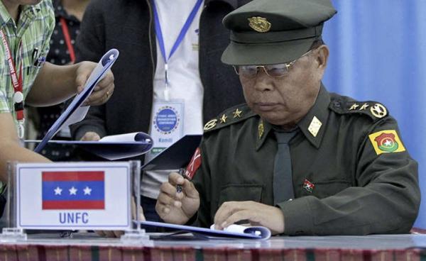 N'Ban La, Chairman of the United Nationalities Federal Council (UNFC), signs a common agreement for a nationwide ceasefire during the Ethnic Armed Organizations Conference in Laiza, Kachin State, Myanmar, 02 November 2013. Photo: Nyein Chan Naing/EPA