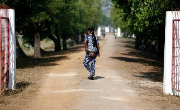 An armed policeman walks by the gate near Taungpyo Bangladesh-Myanmar border entrance in Maungdaw district, Rakhine State of western Myanmar. Photo: Lynn Bo Bo/EPA