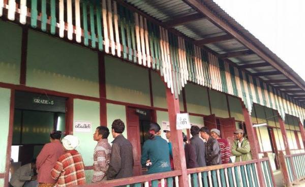 People stands in line at the polling station in Pyun Thone Lone Village of Kachin Sate's Mogaung Township to cast their votes on the Election Day