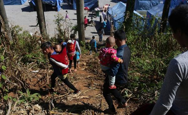 A picture made available on 23 November 2016 of Myanmar refugees carrying children and their belongings arriving at a refugee camp near the border of China and Myanmar in Wanding town, Ruili city of Yunnan province in southwest China, 21 November 2016. Photo: EPA