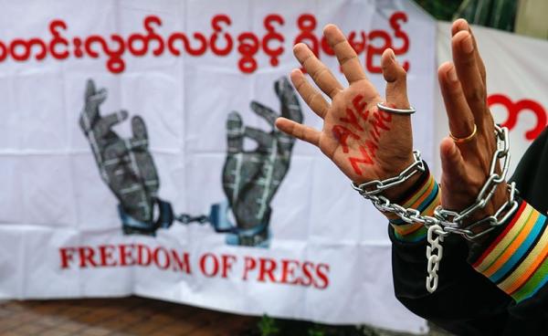 A reporter raises his hands while wearing chains during a demonstration held to demand the Myanmar government and Myanmar military release detained journalists, in front of Yangon City Hall, Yangon, Myanmar, 30 June 2017. Photo: Lynn Bo Bo/EPA