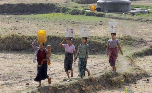 Myanmar women carrying buckets on their heads collect drinking water from the outskirts of Naypyitaw, Myanmar, 25 April 2016. Photo: EPA