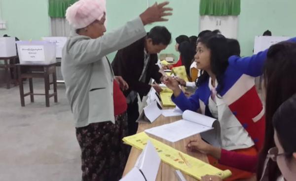 မဲပေးရန်လာသူများကို မဲရုံတာဝန်ရှိသများ လမ်းညွန်နေစဉ်