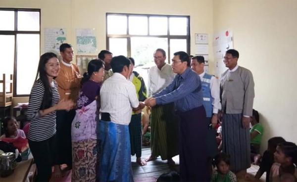 Union Minister Dr. Win Myat Aye, centre-right, accepts a cash donation for families residing at temporary relief camps due to flash floods occurring in their homes in Mottama of Mon State. Photo: MNA