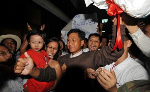 This file photo taken on January 13, 2012 shows Kyaw Min Yu (C), known as Jimmy, and his wife Ni Lar Thein (L) holding her child, both members of the 88 Generation student group, celebrating upon their arrival at Yangon international airport following their release from detention. Photo: AFP