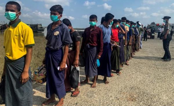 Released Rohingya prisoners wearing face masks amid concerns of the COVID-19 coronavirus pandemic arrive in Sittwe jetty in Rakhine State after being transported by military boat on April 20, 2020. Photo: AFP 