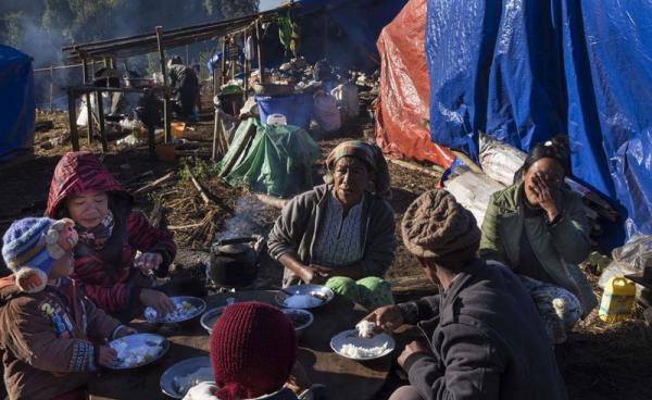 A Kachin refugee family eating near Lung Byeng village in Waimaw township in Kachin state. Photo: Hkun Lat/AFP