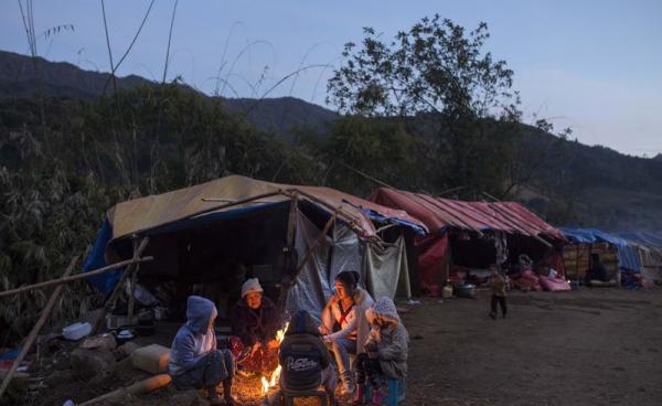 This photo is taken on January 21, 2017 shows a refugee family in front of their temporary shelter near Lung Byeng village, Waimaw township in Kachin state. Photo: Hkun Lat/AFP