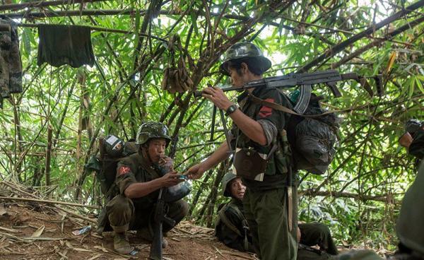 In this photograph taken October 14, 2016, armed rebels belonging to KIA ethnic group take a cigarette break as they move towards the frontline near Laiza in Kachin state. Photo: Hkun Lat/AFP