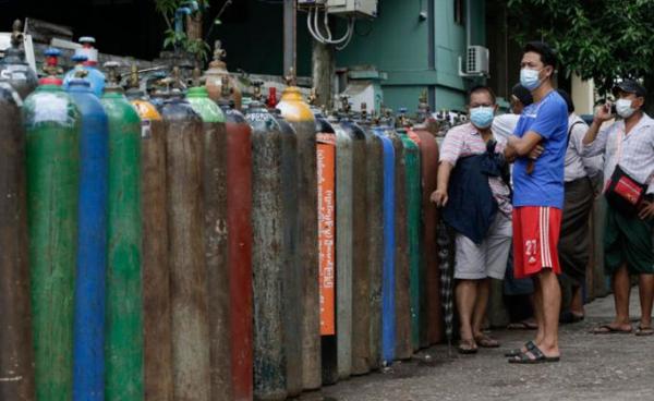 Myanmar people wait near oxygen tanks lined up to refill outside an oxygen factory in Yangon, Myanmar, 11 July 2021. Photo: EPA