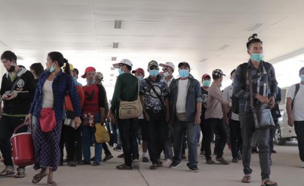 Myanmar nationals wearing facemasks amid concerns over the spread of the COVID-19 coronavirus walk at the immigration post in Myawaddy near the Thai border on March 23, 2020, as thousands of people crossed from Thailand as the border crossings were due to close because of the growing pandemic. Photo: AFP