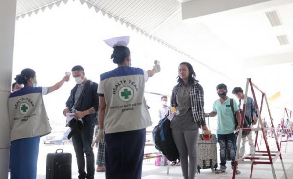 People have their temperatures checked amid concerns over the spread of the COVID-19 coronavirus at the immigration post in Myawaddy near the Thai border on March 23, 2020, as thousands of people crossed from Thailand as the border crossings were due to close because of the growing pandemic. Photo: AFP