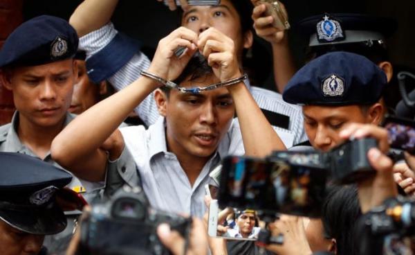 Reuters journalist Kyaw Soe Oo (C) is escorted out of the Insein township court in Yangon, Myanmar, 03 September 2018. Photo: Lynn Bo Bo/EPA