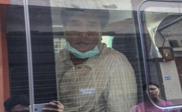 Voice of Myanmar (VOM) editor-in-chief Nay Myo Lin (C) sits in a vehicle as he is escorted from his home by the police to court in Mandalay on March 31, 2020. Photo: Zaw Zaw/AFP