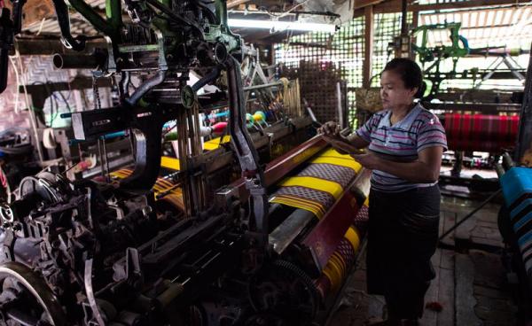 A woman working to make traditional Myanmar clothing at a workshop in Mandalay. Photo: Ye Aung Thu/AFP