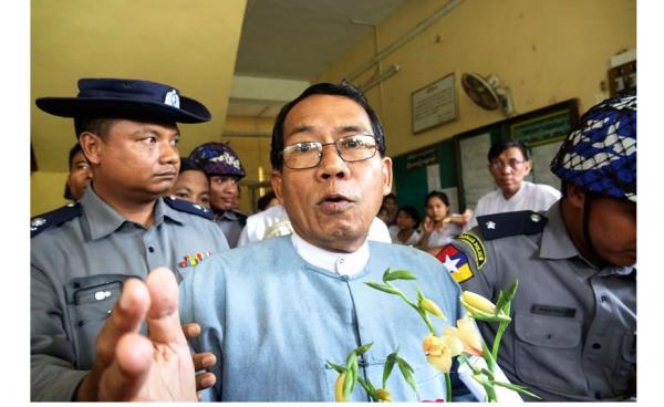 Dr Aye Maung (C), Ann Township MP and former Arakan National Party leader, talks to members of the media while being escorted out of court by police officers after a hearing on his trial at Sittwe court, in Sittwe, Rakhine State, western Myanmar, 13 August 2018. Photo: Nyunt Win/EPA