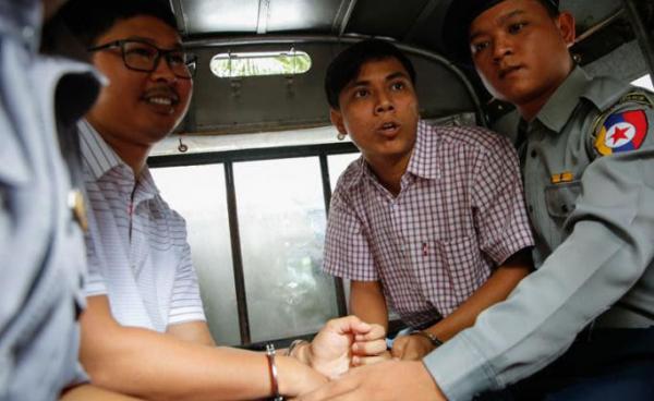 Reuters journalist Wa Lone (C-L), 31, and Kyaw Soe Oo (C-R), 28, sit in the police truck as they leave the court after the verdict has postponed at Insein township court, Yangon, Myanmar, 27 August 2018. Photo: Lynn Bo Bo/EPA
