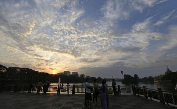 People watch the last sunset of the year at the Kandawgyi Park in Yangon. Photo: Nyein Chan Naing/EPA