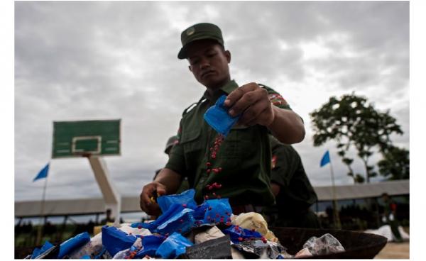 Member of the UWSA  empties a packet of 'WY' also know as Ya Ba before they are set on fire during a drug burning ceremony, near the Thai and Myanmar border on June 26, 2017. Photo: Ye Aung Thu/AFP