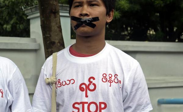 Reuters journalist Wa Lone wearing a t-shirt with a slogan reading, 'Stop killing press' and tapes on his mouth takes part in a protest over their jailed colleagues, near the Myanmar Peace Center in Yangon, 12 July 2014  (Photo: Nyein Chan Naing/EPA)