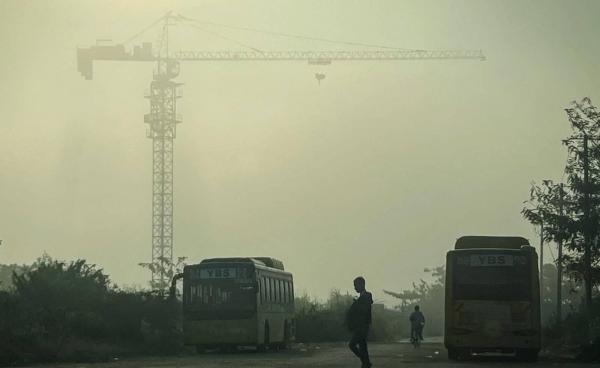 ဇန်နဝါရီ ၂၇ ရက်နေ့တွင် မြူခိုးများ အုပ်ဆိုင်းနေသည့် ရန်ကုန်မြို့မြင်ကွင်းအချို့။ (ဓာတ်ပုံ – Sai Aung MAIN / AFP)