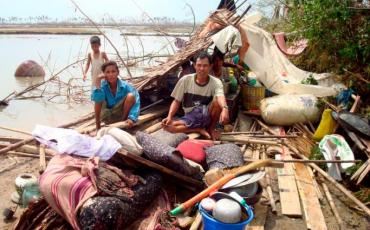 A Myanmar family sits on the remains of their house in Bogolay, the Irrawaddy Delta, 14 May 2008. Photo: EPA